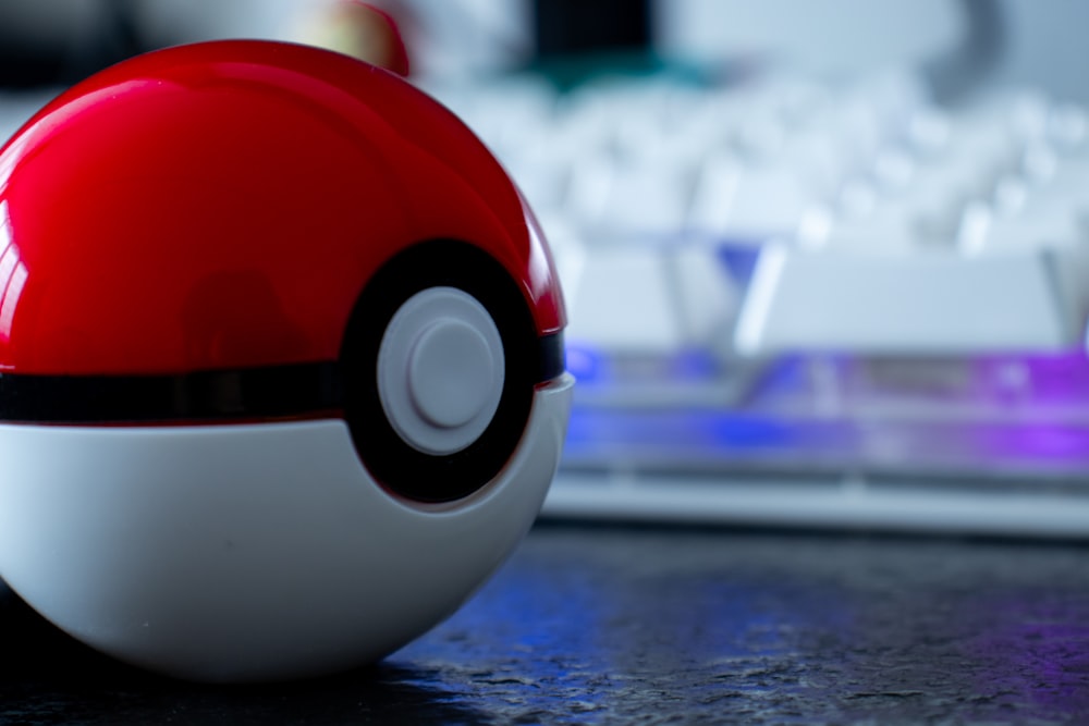 a close up of a red and white ball on a desk