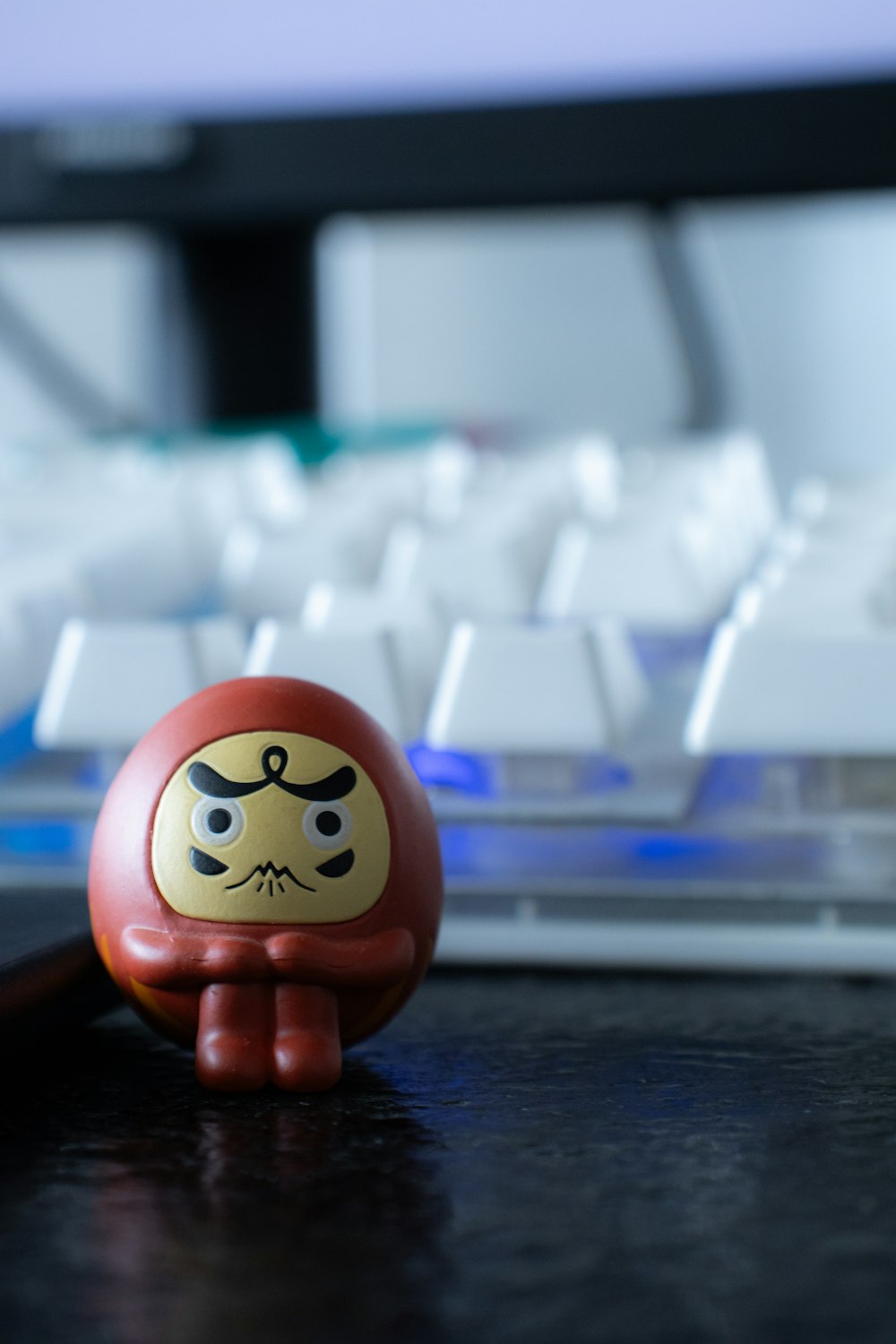 a small toy sitting in front of a computer keyboard