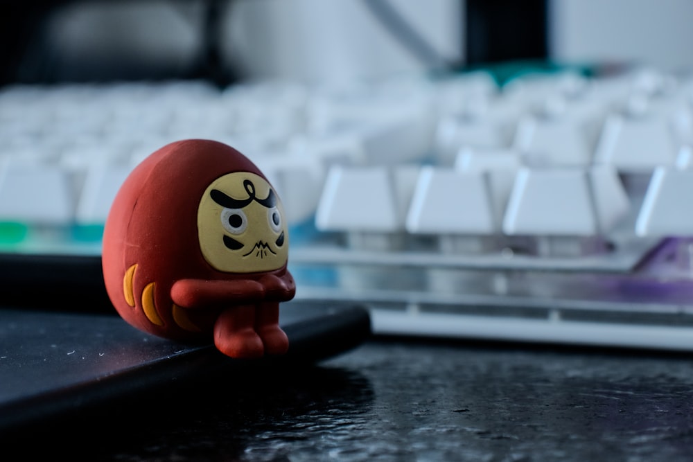 a small toy sitting on top of a desk next to a keyboard