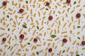 A neatly arranged flat lay of ingredients for a simple pasta dish on a soft neutral-tone background