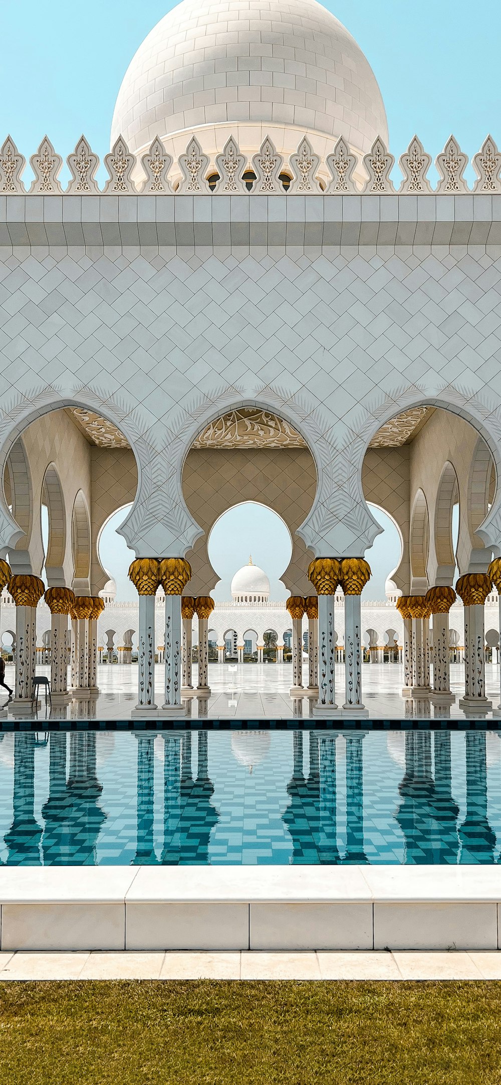 a large white building with a pool in front of it