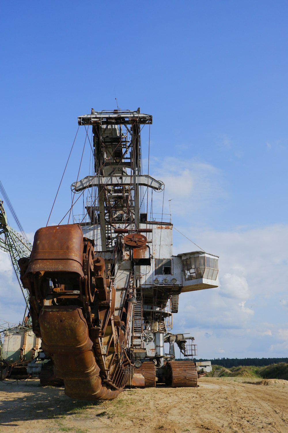 a large rusted out machine sitting on top of a dirt field