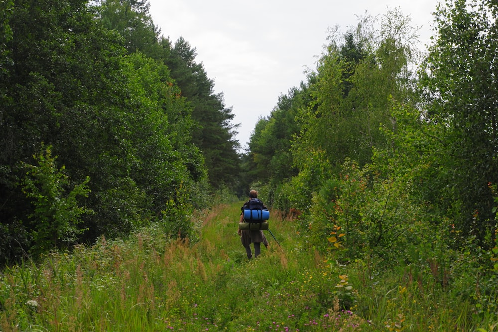 a man with a backpack walking through a forest