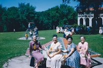 A group of diverse mothers smiling together in a park.