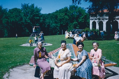 A group of diverse mothers smiling together in a park.