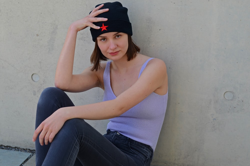 a woman sitting on the ground with her hand on her head