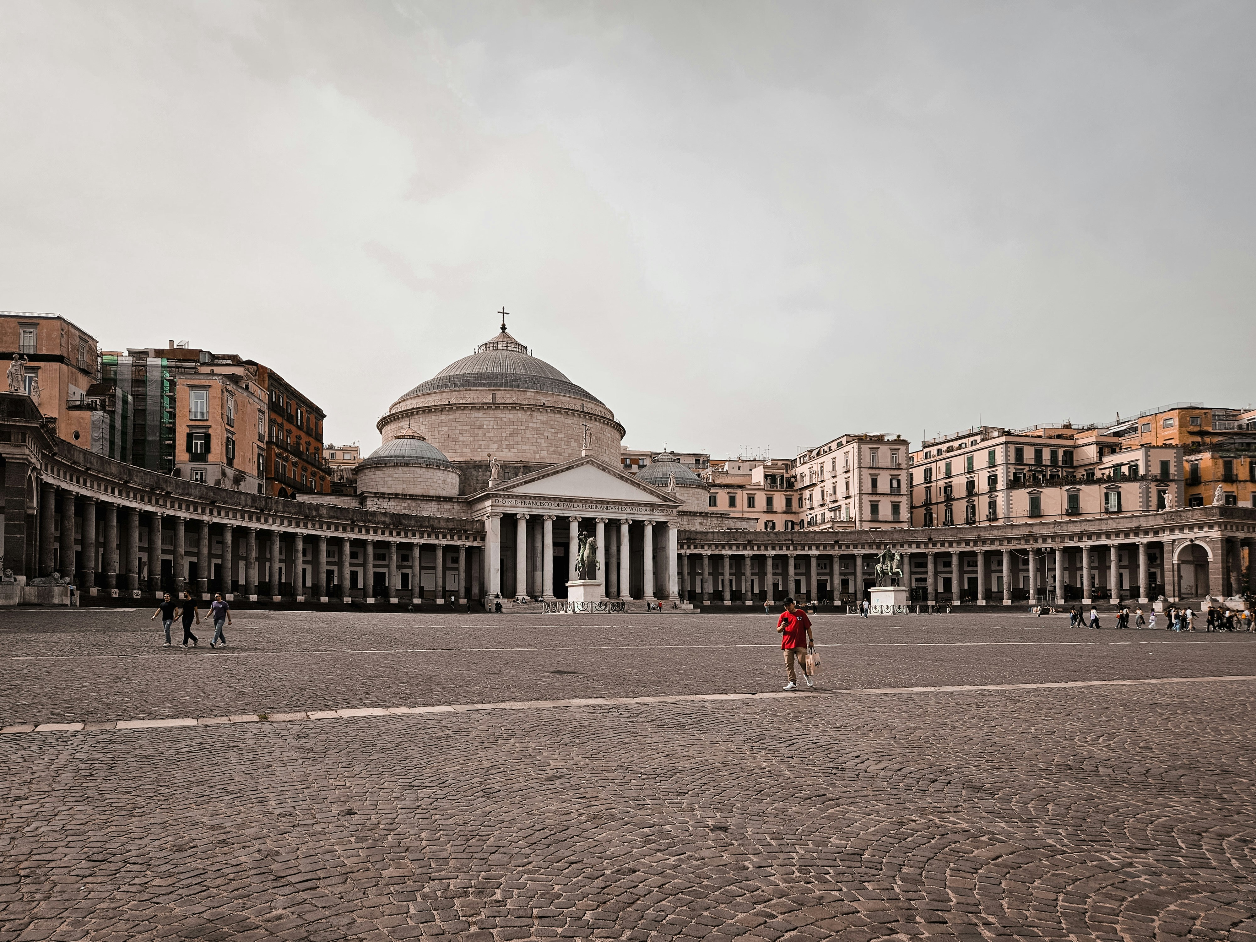 a large courtyard with a domed building in the background