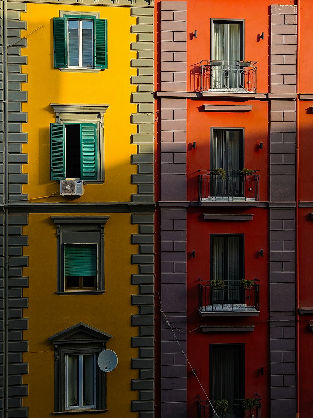 a row of multicolored buildings with windows and balconies