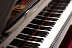 a close up of a piano with red strings