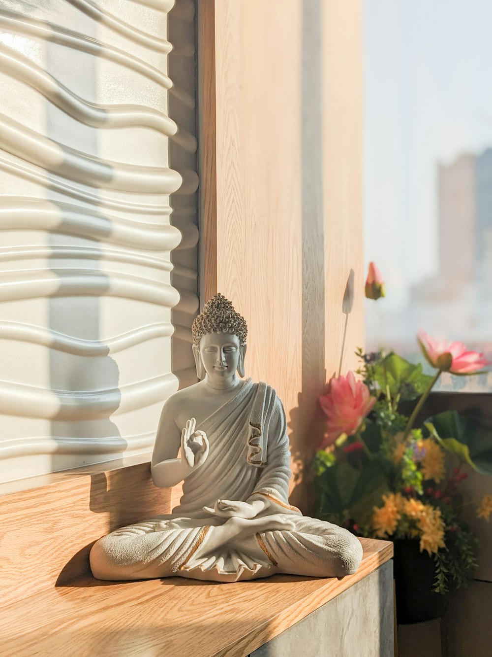 a buddha statue sitting on top of a wooden table