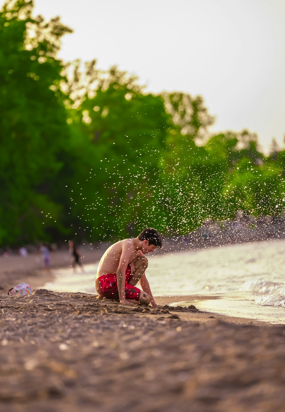 a boy playing in the water on a beach