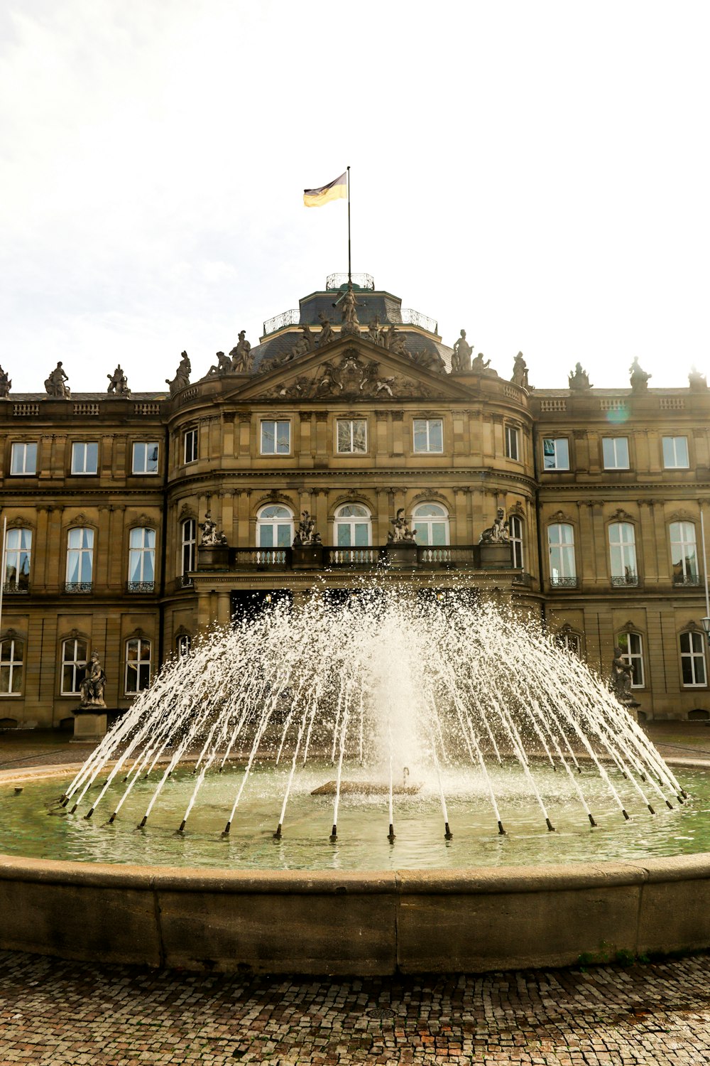 Un gran edificio con una fuente frente a él