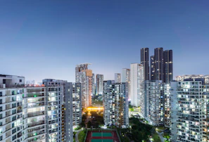 Evening shot of a cityscape highlighting illuminated modern apartment complexes