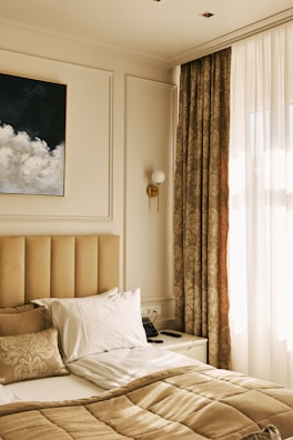 A cozy bedroom with warm beige walls and neat finishing touches from a recent paint job.