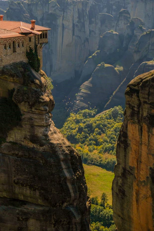An ancient monastery nestled among towering green hills, bathed in soft morning light.