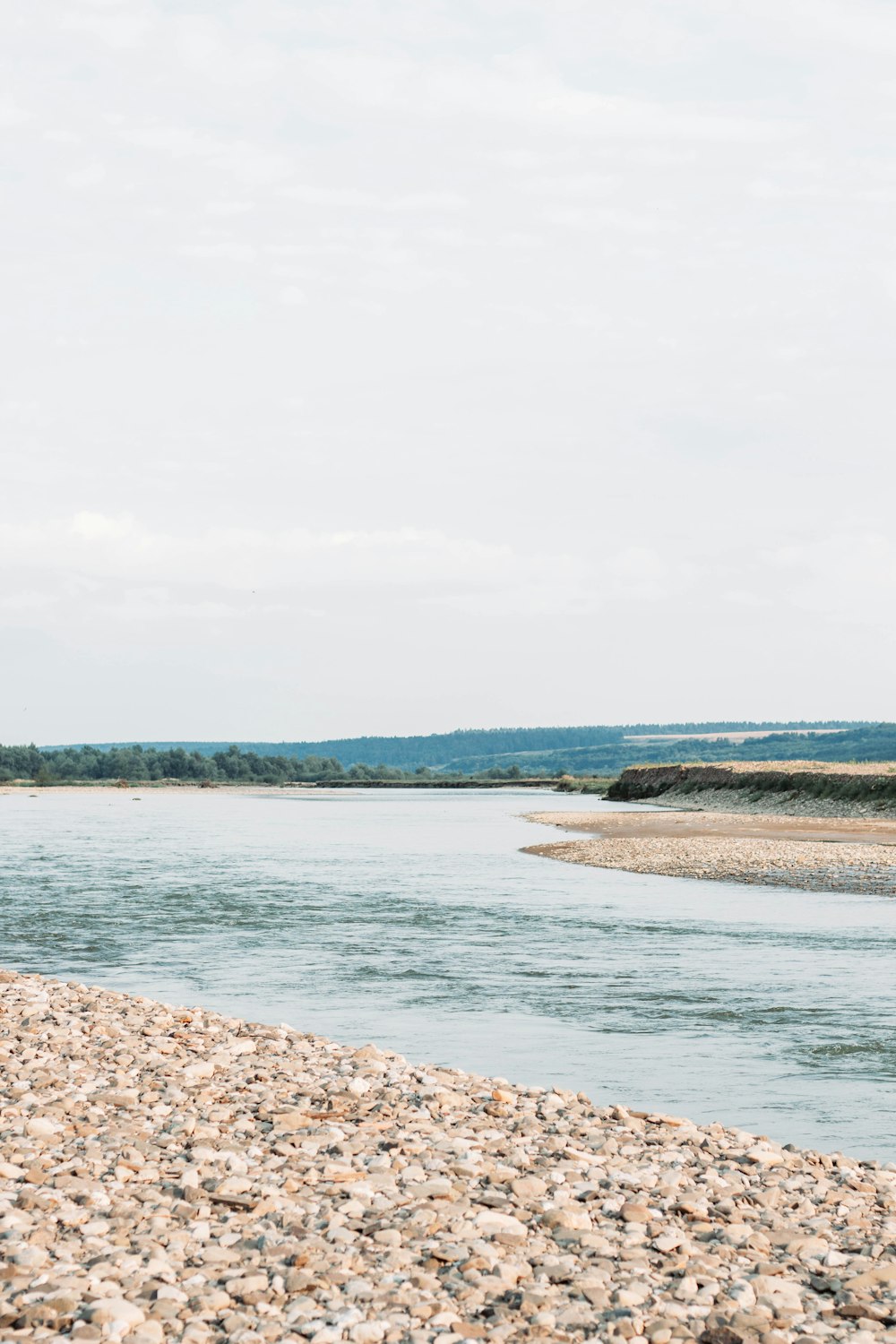 a man standing on a beach next to a body of water