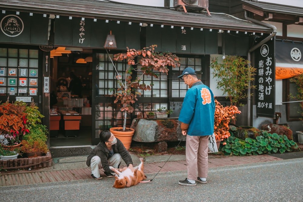 a man standing next to a dog on a sidewalk