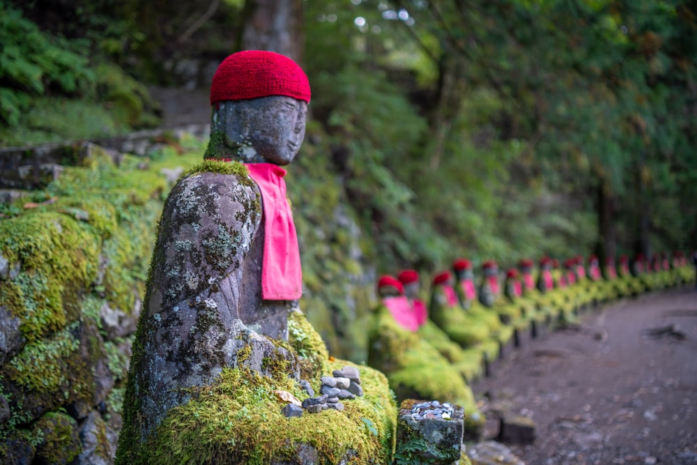 a row of buddha statues covered in moss
