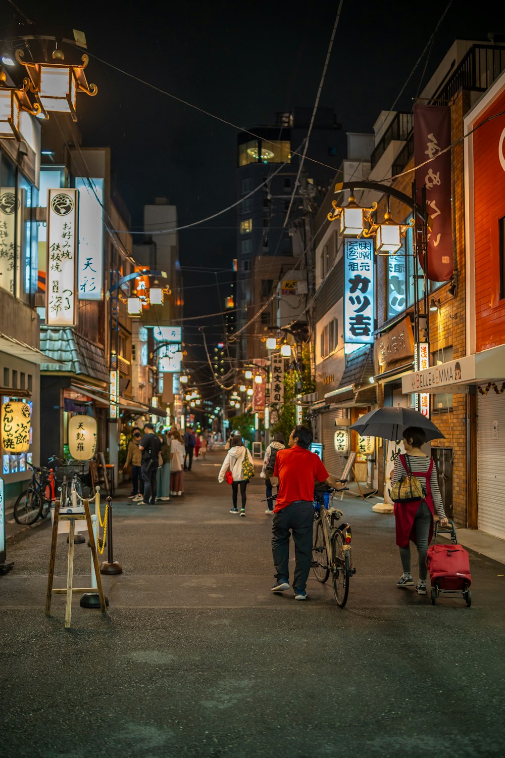 a group of people walking down a street holding umbrellas