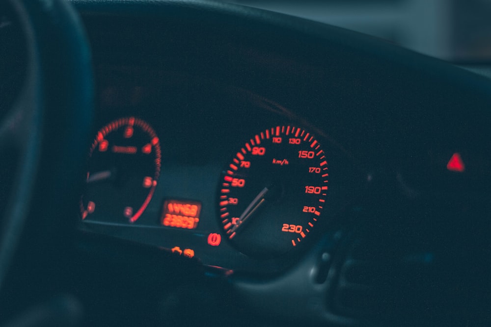 the dashboard of a car with red and white lights