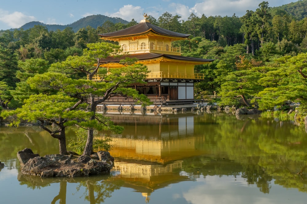 a yellow building sitting on top of a lush green hillside