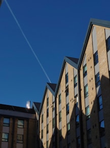 a plane flying in the sky over a building