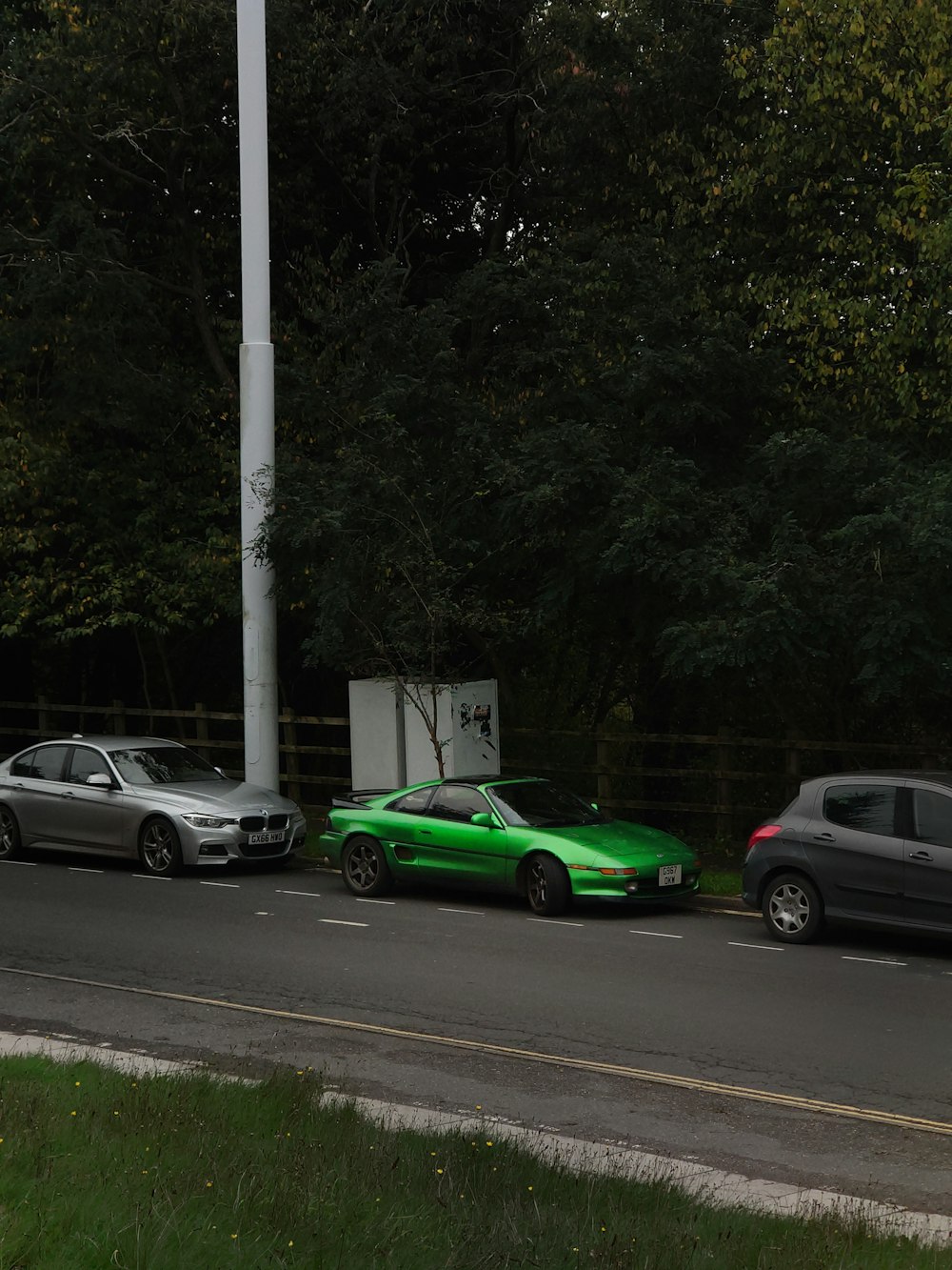 three cars parked on the side of the road
