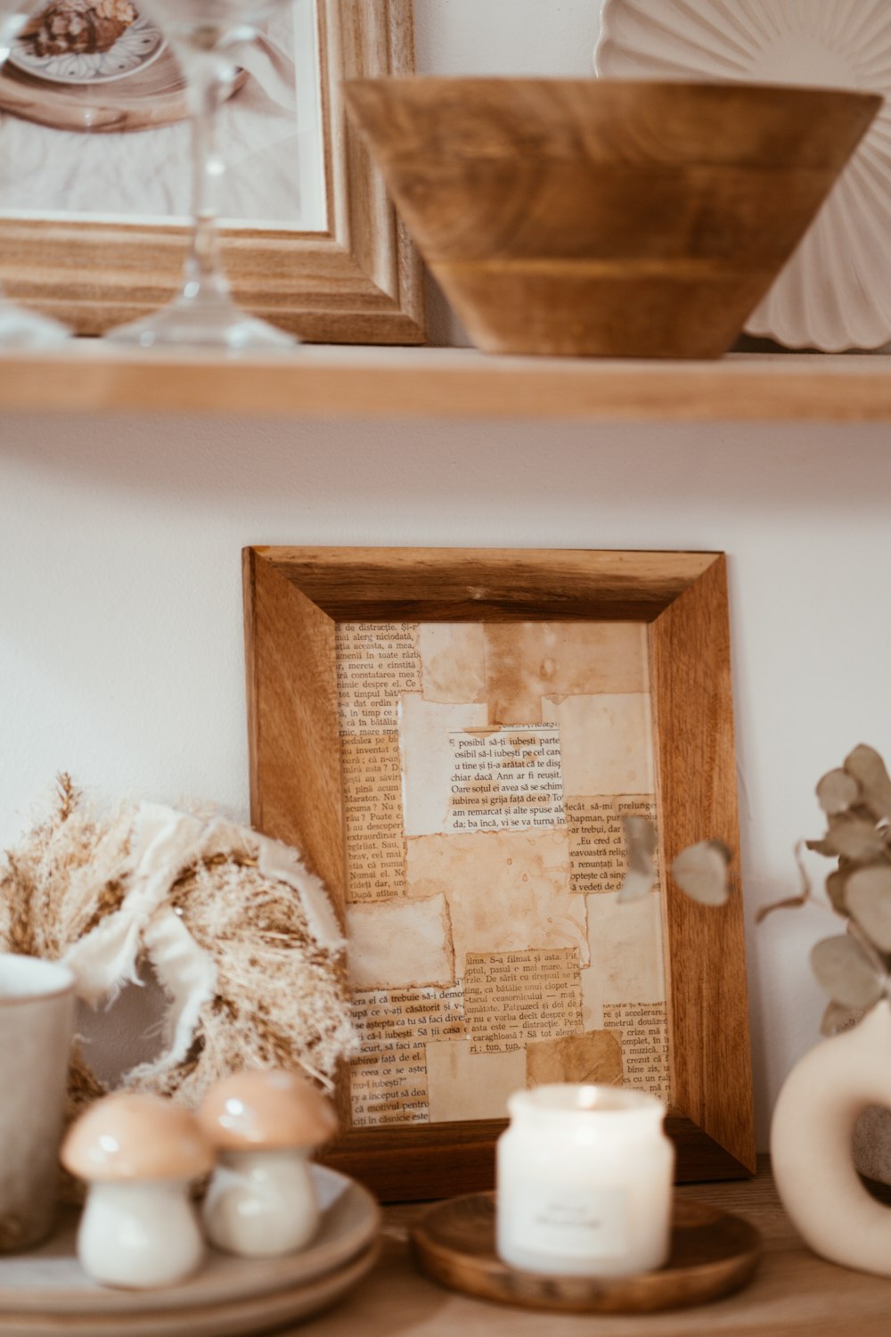 a shelf with a picture, candles and other items on it