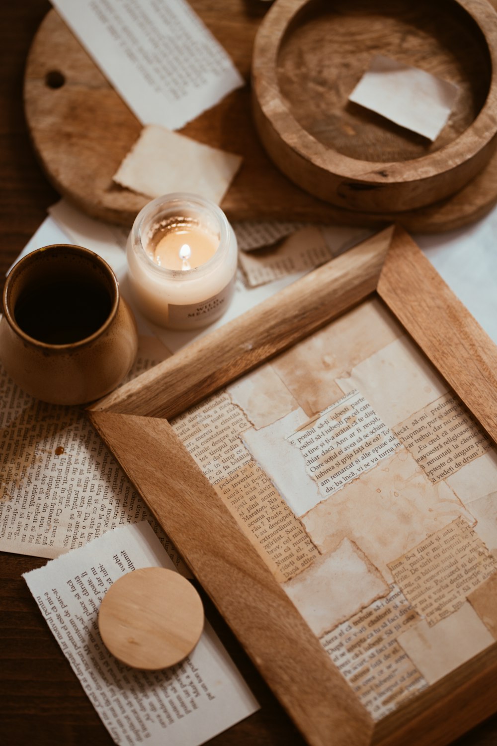 a wooden frame with a candle and some papers