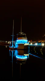 Underwater LED lights illuminating a yacht hull in deep blue water