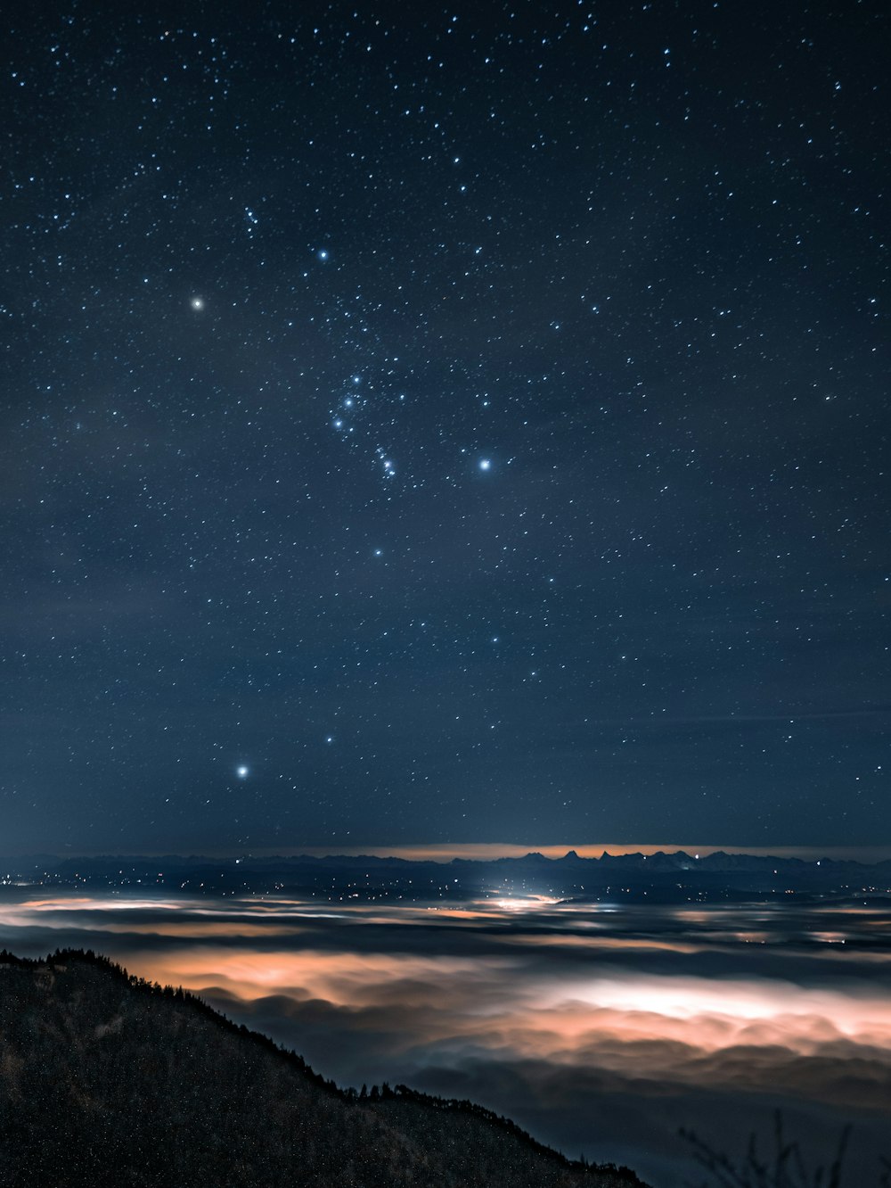the night sky with stars above the clouds