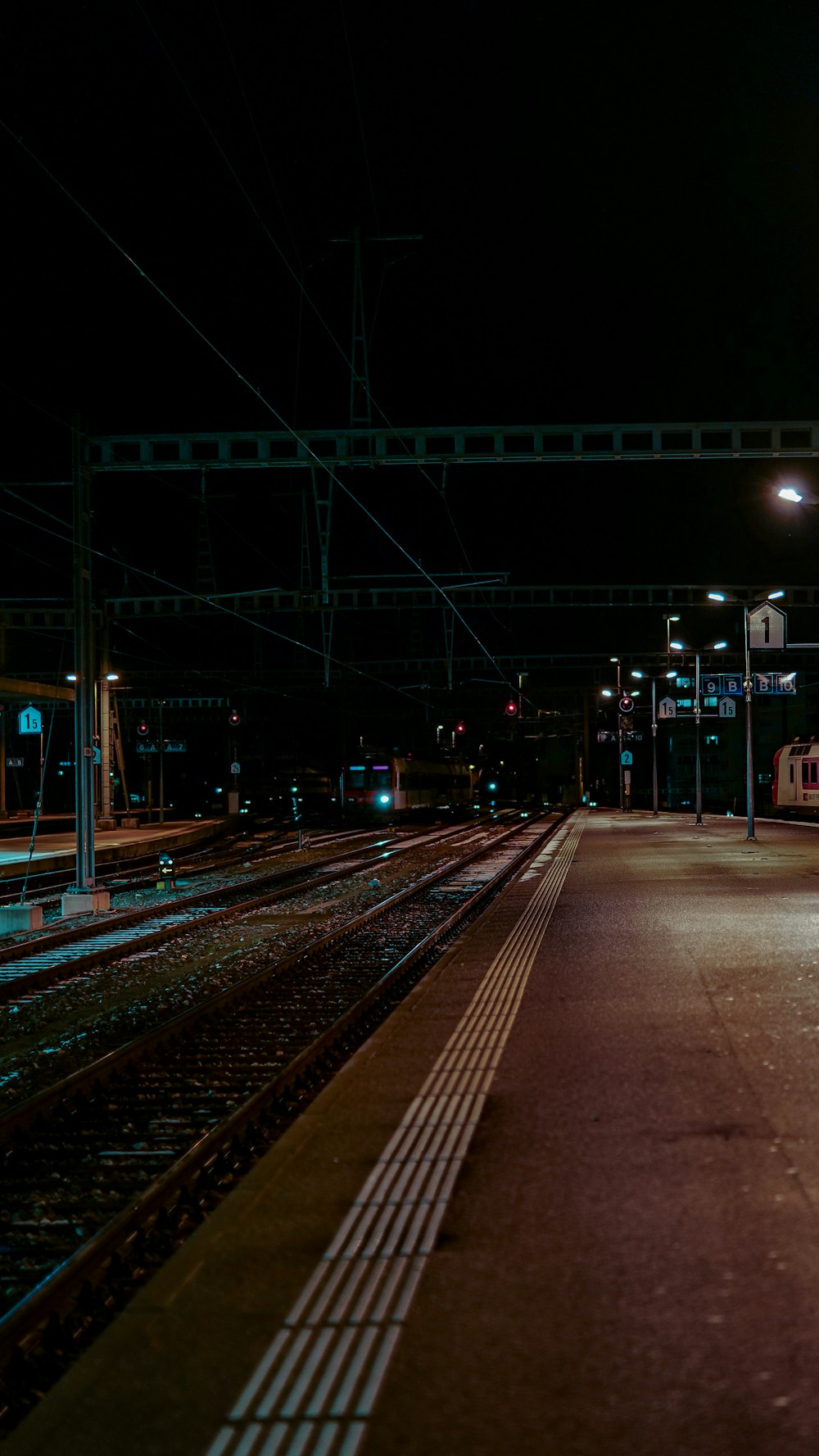 a train station at night with a train on the tracks