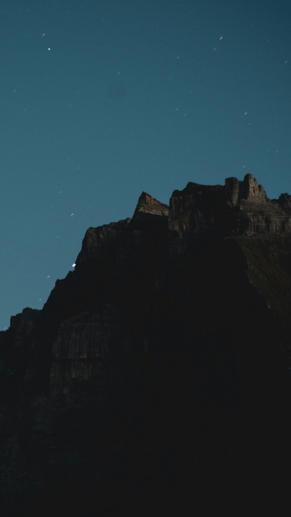 a mountain with a moon in the sky