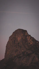A rugged mountain peak at dawn symbolizing strength and endurance.