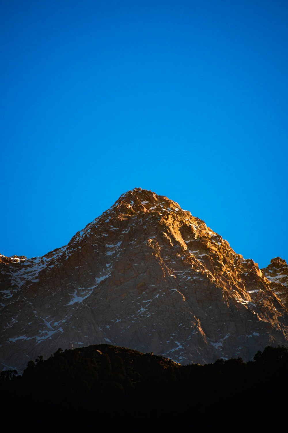 a large mountain with a blue sky in the background
