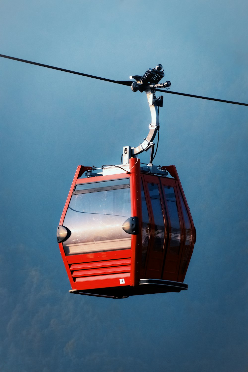 a red cable car with a sky background