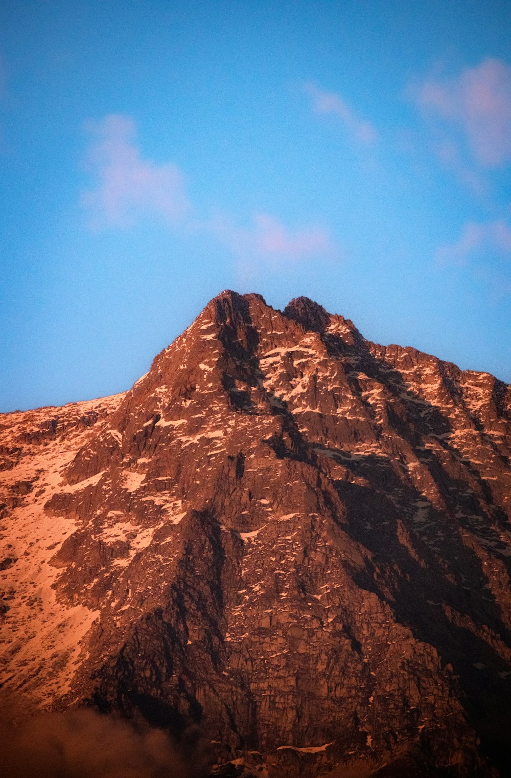 a very tall mountain with a blue sky in the background