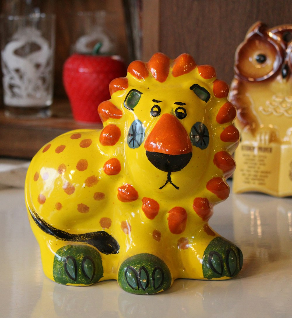 una figurita de león amarillo sentada encima de una mesa