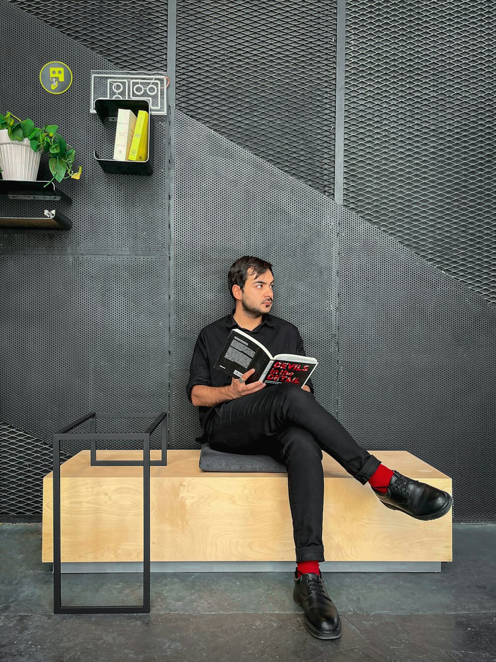 a man sitting on a bench reading a book