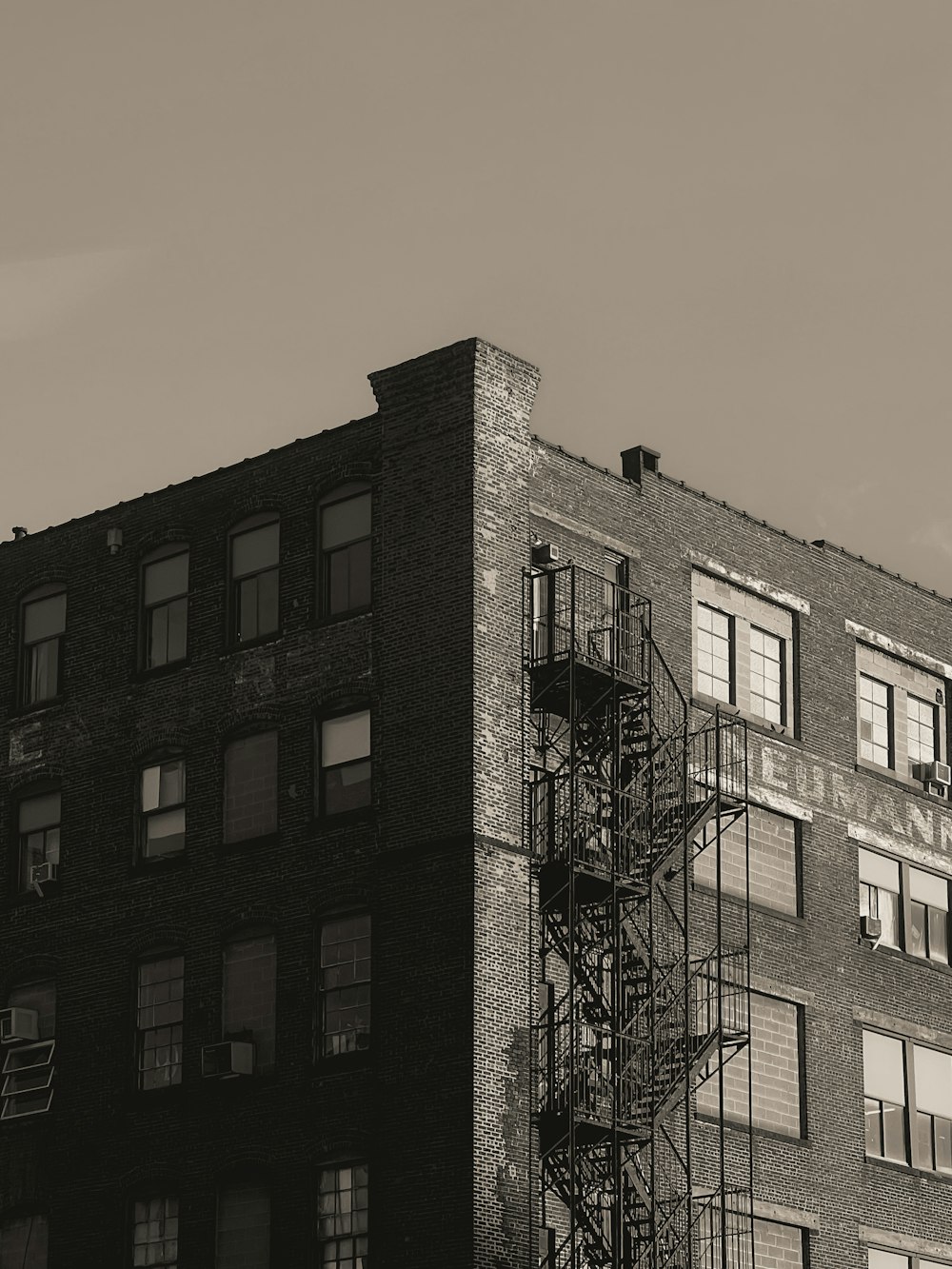 a black and white photo of a building with a fire escape