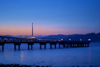 A serene photo of a glowing bridge over calm water at sunset, symbolizing connection and hope.