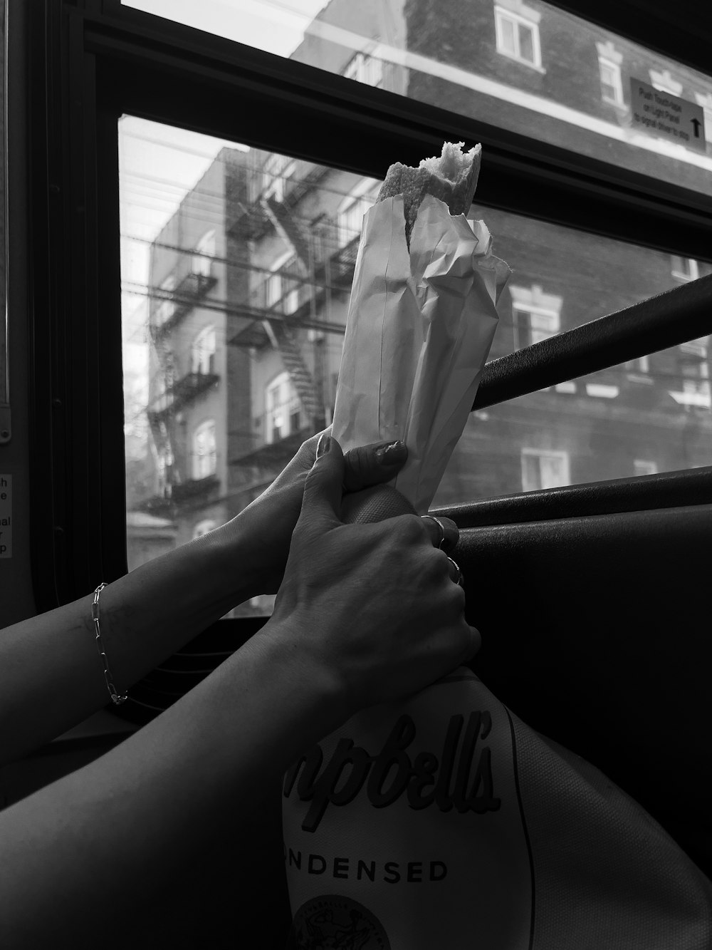 a person holding a paper bag on a bus