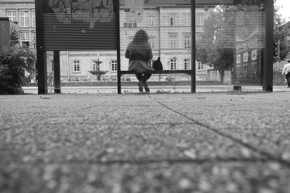 a person sitting on a bench in front of a building