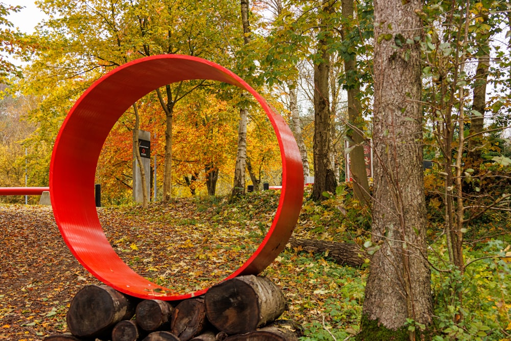 a red sculpture in the middle of a forest