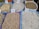 Various types of legumes and grains are displayed in bags at a market. Each bag is marked with a handwritten price sign. The bags include beans, lentils, and chickpeas, among others.