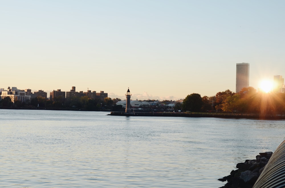 a body of water with a light house in the background