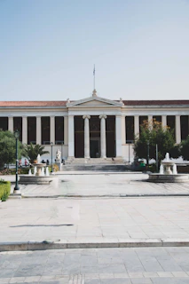 a large building with columns and a flag on top of it