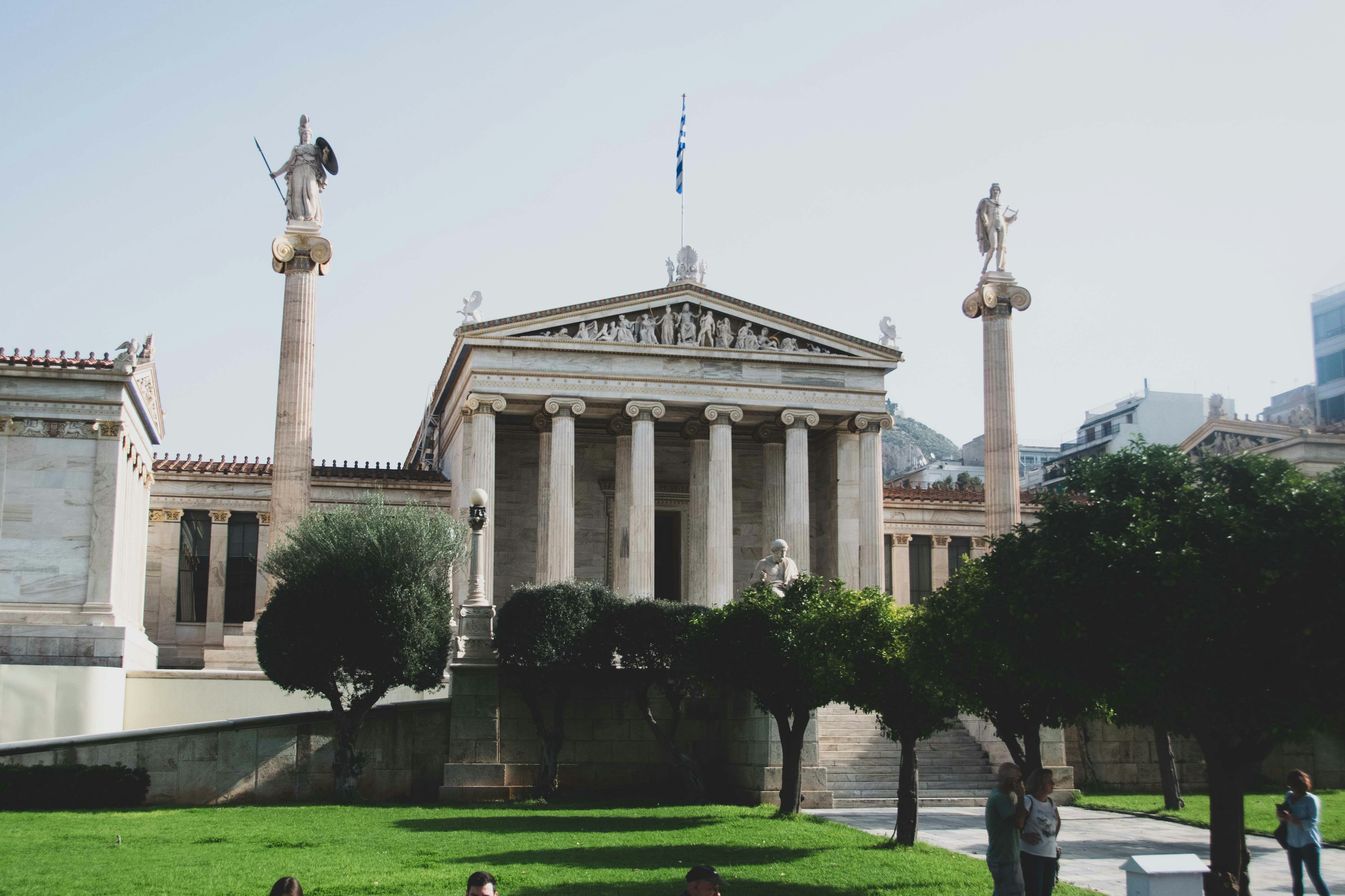 a group of people sitting on the grass in front of a building