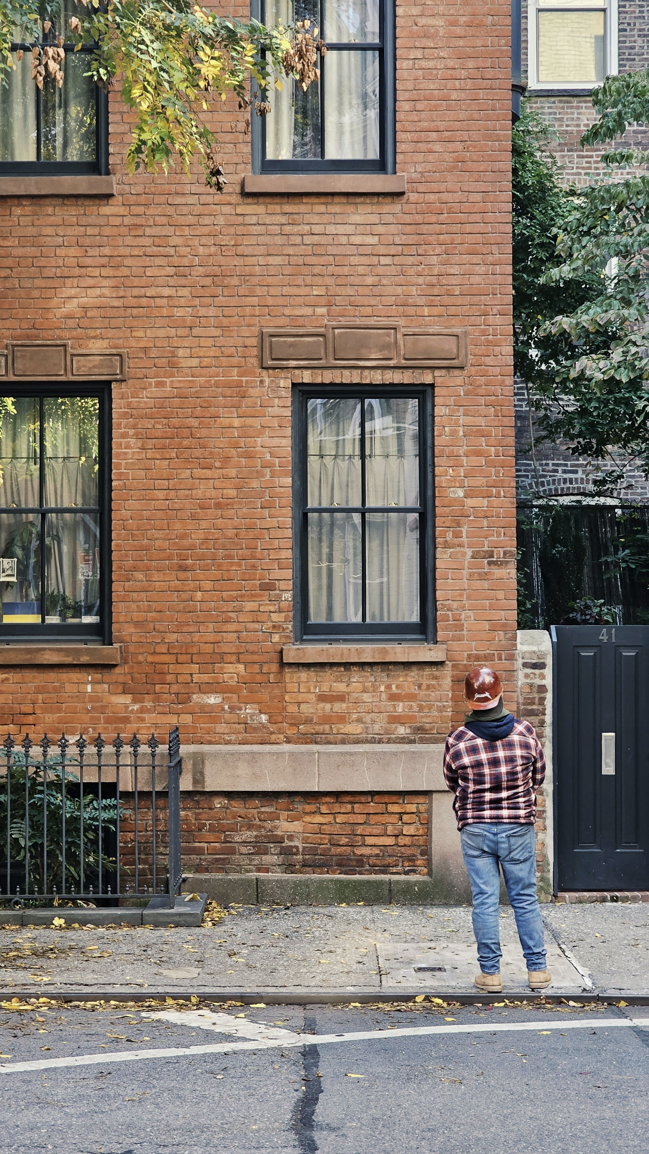 a man standing in front of a brick building