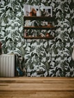 a room with a wooden floor and a wall with plants on it